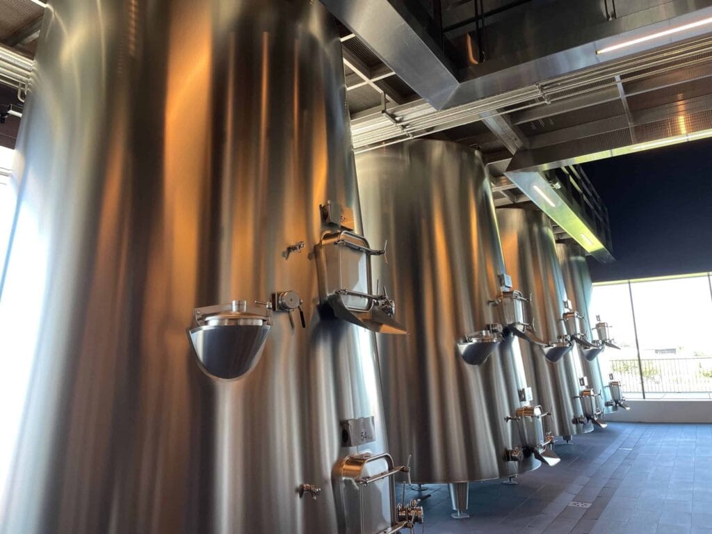 Edelstahltanks für die Weinherstellung im Château Pédesclaux, Pauillac, Bordeaux, Grand Cru Classé du Médoc, in einem modernen Weingut mit natürlichem Licht.