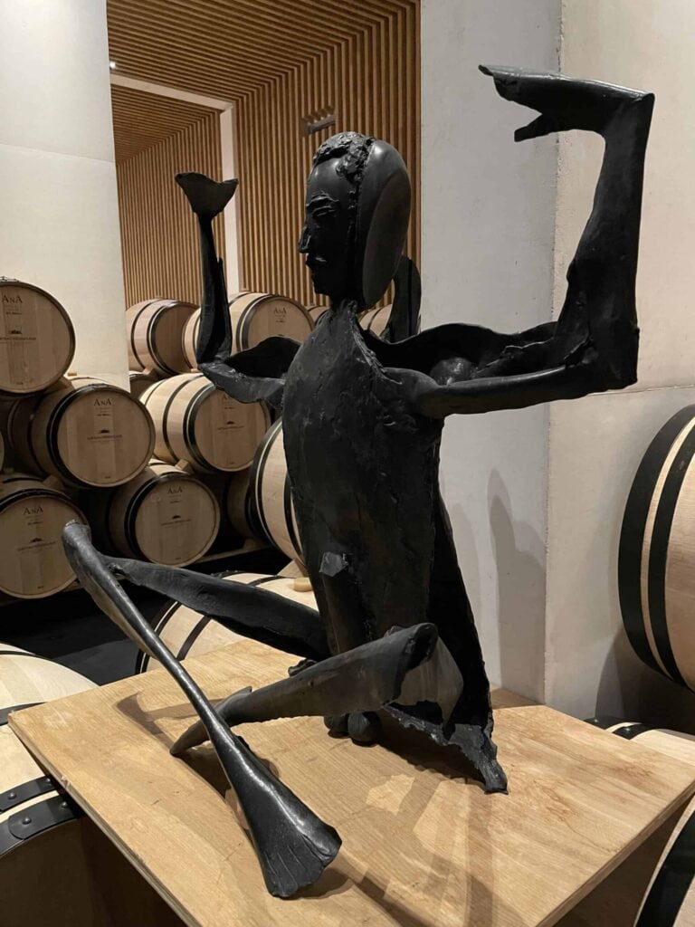 Zeitgenössische Skulptur aus schwarzem Metall im Weinkeller von Château Pédesclaux in Pauillac, umgeben von Eichenfässern zur Reifung von Weinen, Grand Cru Classé aus dem Médoc, Bordeaux.