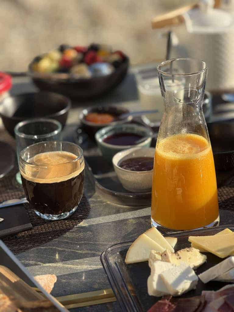 Accueil 15 Petit-déjeuner gourmand sur la terrasse du Château Papounan à Saint-Estèphe, Médoc : carafe de jus d’orange frais, café, croissants, fromages artisanaux et viennoiseries, dans une chambre d’hôtes de charme près des vignobles de Bordeaux.