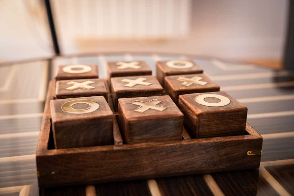 Jeu de société décoratif en bois sur la table basse dans la Suite l’Estuaire du Château Papounan, chambre d’hôtes de charme à Saint-Estèphe, Médoc.