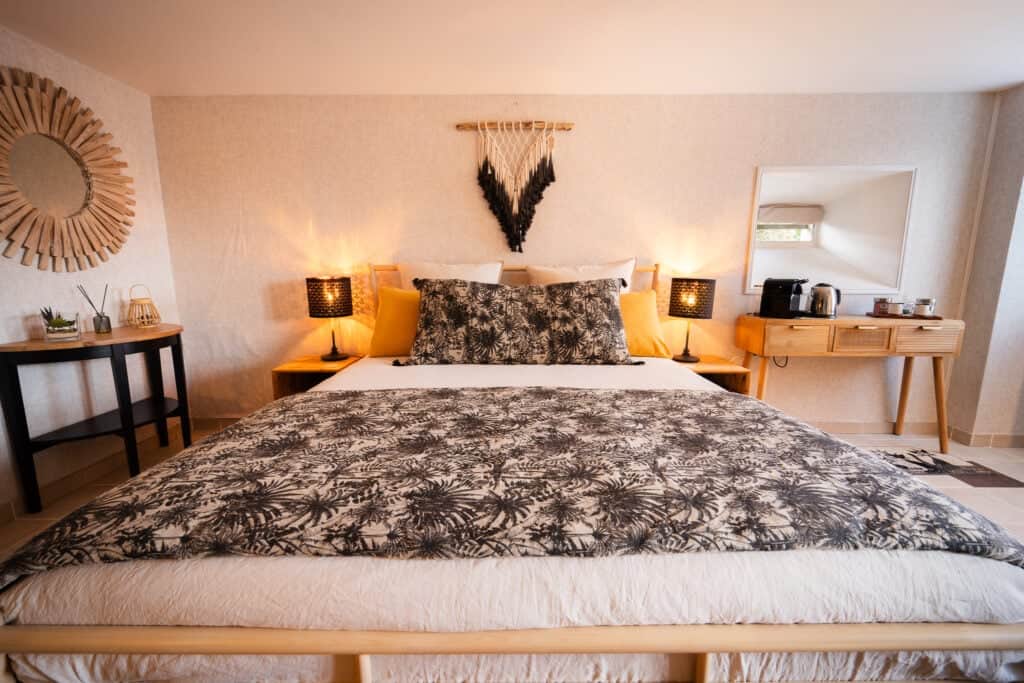 Lit 160x200 avec linge en lin et décoration bohème chic dans le Studio Les Vignes du Château Papounan, chambre d’hôtes de charme à Saint-Estèphe, Médoc.