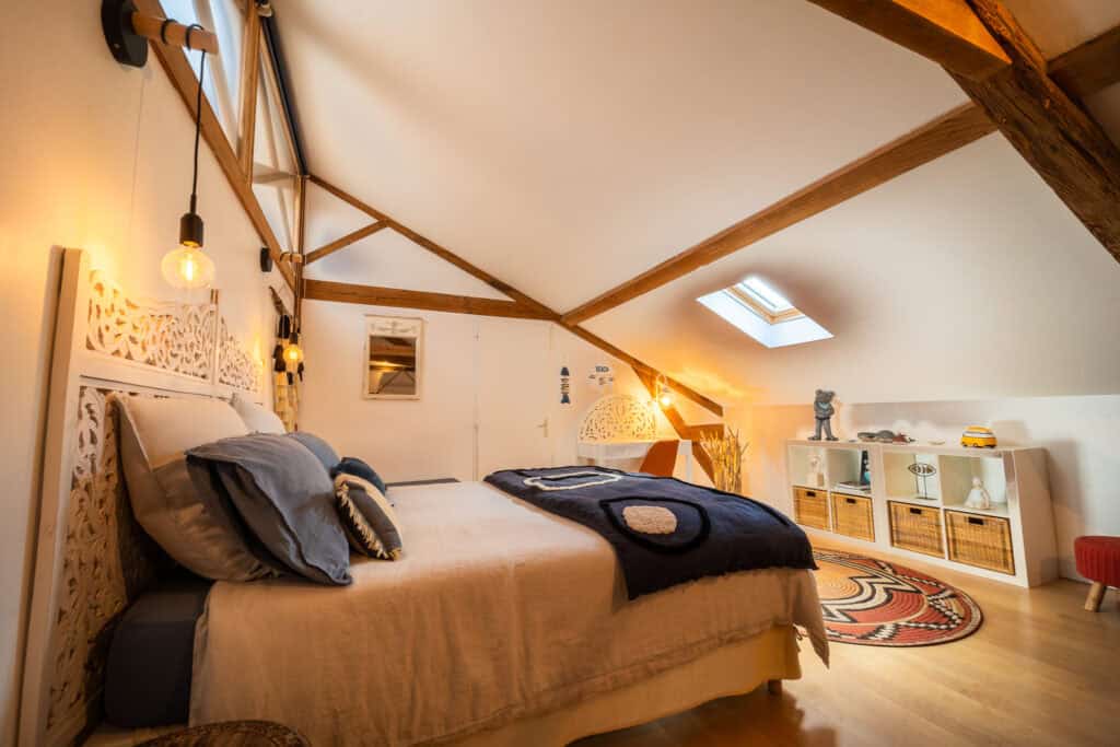 Lit 160x200 avec linge en lin, espace bureau et décoration bohème chic dans la Suite Océane du Château Papounan, chambre d’hôtes de charme à Saint-Estèphe, Médoc.