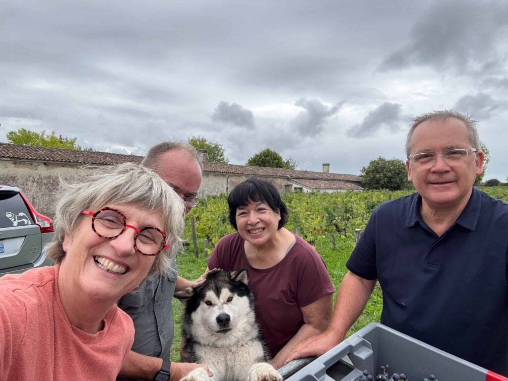Réjane, Marc, Sylvaine et Jacques avec Amarok le Malamute d'Alaska devant le vignoble du Château Papounan